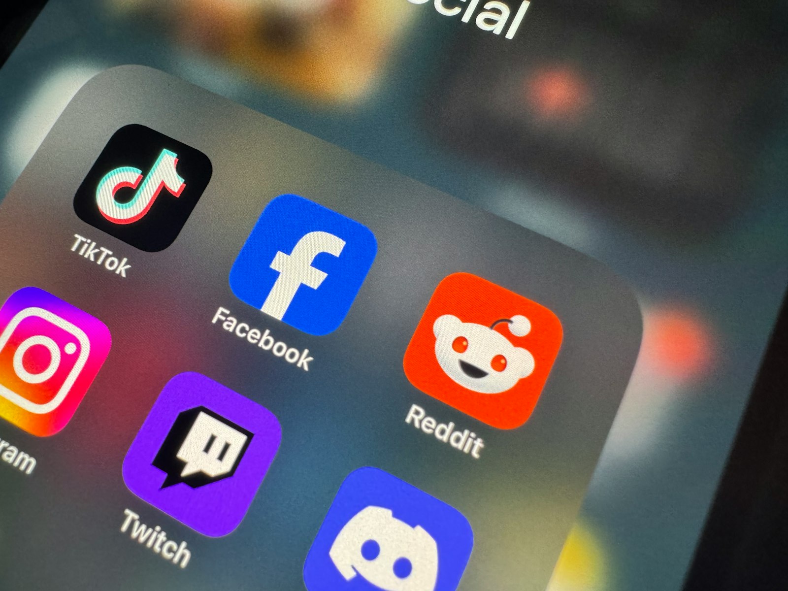 Close-up of a phone home screen showing the Reddit, Facebook, TikTok and Instagram app icons